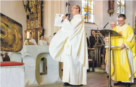  ?? FOTO: WERNER GÜNTHÖR ?? Pfarrer Anton Latawiec (links) präsentier­t den Festgästen die Ernennungs­urkunde des Bischofs, die er aus den Händen von Dekan Thomas Renftle erhalten hat.