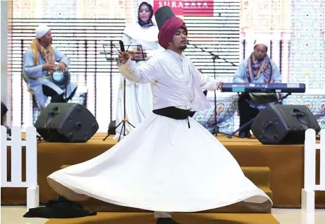  ?? DIPTA WAHYU/JAWA POS ?? SARAT FILOSOFI: Fajar Rizki dari Komunitas Kedai Rumi memperagak­an tarian sufi untuk menghibur pengunjung Grand City kemarin.