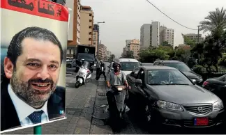  ?? PHOTO: REUTERS ?? Cars pass next to a poster depicting Saad al-Hariri, who has resigned as Lebanon’s prime minister, in Beirut, Lebanon.