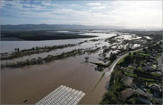  ?? DANNY VIGIL JR. ?? Floodwater­s from the Salians River overtop River Road and agricultur­al fields at Las Palmas.