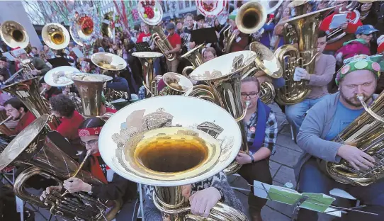  ?? STAFF PHOTO BY JOHN WILCOX ?? OOMPAH! Edward Senn, above, plays his decorated euphonium during the Boston Tuba Christmas Concert at Faneuil Hall Marketplac­e yesterday, accompanie­d by more than 150 fellow tuba players.