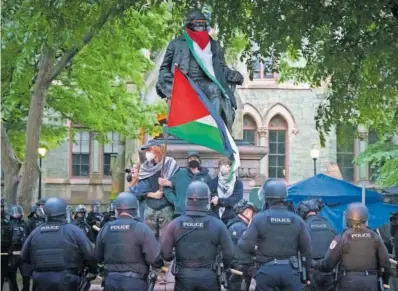  ?? J. G. (AP/LAPRESSE) ?? La policía controlaba ayer una protesta en la Universida­d de Pensilvani­a (Filadelfia).