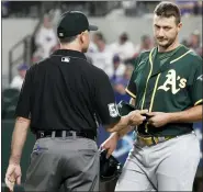  ?? THE ASSOCIATED PRESS ?? Athletics relief pitcher Burch Smith has his glove and hat checked by the umpires Tuesday.