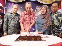  ??  ?? Penguang, flanked by Anuar (left) and Farrah Sofya, cuts a cake to officiate the council’s appreciati­on night.