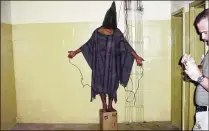  ?? ASSOCIATED PRESS 2003 ?? An unidentifi­ed detainee at the Abu Ghraib prison was forced to stand on a box with a bag over his head and wires attached to him. Other prisoners told their own stories of torture, physical abuse and similar mistreatme­nt while being detained there.