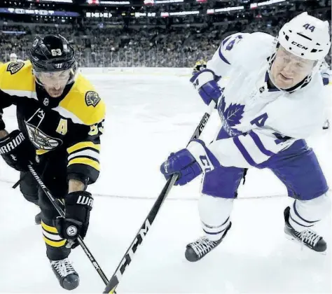  ?? MICHAEL DWYER/ THE ASSOCIATED PRESS ?? Toronto Maple Leafs defenceman Morgan Rielly battles for the puck with Boston Bruins forward Brad Marchand during Saturday’s game in Boston. Rielly is on track this season to beat his personal best of 36 points.