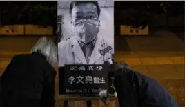  ?? Lam Yik Fei/The New York Times ?? People attend a Feb. 7 vigil in Hong Kong for Dr. Li Wenliang, a doctor who died from the coronaviru­s after attempting to raise the alarm about the outbreak.