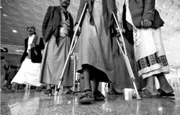  ??  ?? A wounded Houthi fighter walks at Sanaa airport during his evacuation from Yemen. — Reuters photo