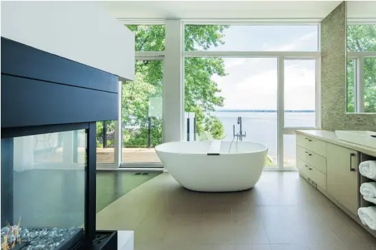  ??  ?? With an unbeatable view of the Ottawa River, this award-winning ensuite aims for a feeling of intimacy and is separated from the master bedroom by just a three-sided fireplace.