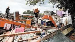  ?? SONNY TUMBELAKA/GETTY-AFP ?? A man salvages belongings Thursday, four days after a quake on Lombok, Indonesia.