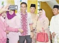  ??  ?? SEORANG pengunjung sempat bergambar kenangan bersama Assafal dan Iman.