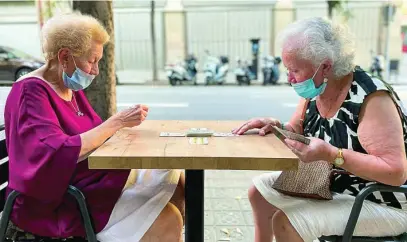  ?? REUTERS ?? Dos mujeres juegan a las cartas en una calle de Barcelona