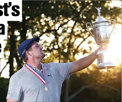  ??  ?? Bryson DeChambeau holds the US Open trophy aloft after winning the tournament by six strokes on Sunday.