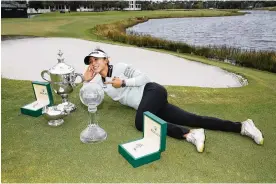  ?? LYNNE SLADKY / AP ?? Lydia Ko poses with the Rolex Player of the Year trophy (left), the Vare trophy (center) and the LPGA CME Group Tour Championsh­ip trophy Sunday.