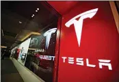  ??  ?? This file photo shows a sign bearing the company logo outside a Tesla store in Cherry Creek Mall in Denver. (AP)