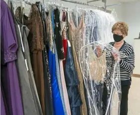  ?? Andrew Rush/Post-Gazette ?? Charlene Ossman, a bridal consultant at Carlisle's Bridal of Pittsburgh for 42 years, covers a dress on Wednesday.