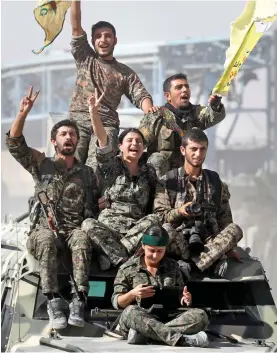  ??  ?? Jubilant: SDF fighters celebrate in the centre of Raqqa yesterday