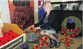  ?? LARRY WONG ?? Volunteer Trudy Ressler helps prepare poppies for the annual campaign.