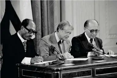  ??  ?? L'égypte et Israël, respective­ment représenté­s par Anouar el-sadate (à gauche) et Menahem Begin, signent la paix sous les auspices du président américain Jimmy Carter, en septembre 1978.