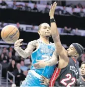  ?? NELL REDMOND AP ?? The Hornets’ P.J. Washington passes as he’s guarded by the Heat’s Jimmy Butler during Sunday’s game.