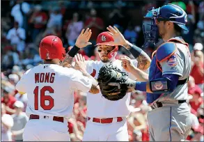  ?? AP/JEFF ROBERSON ?? Kolten Wong (left) and teammate Yadier Molina of the St. Louis Cardinals celebrate after scoring past New York Mets catcher Travis d’Arnaud during the second inning Sunday in St. Louis. The Cardinals won 6-4.