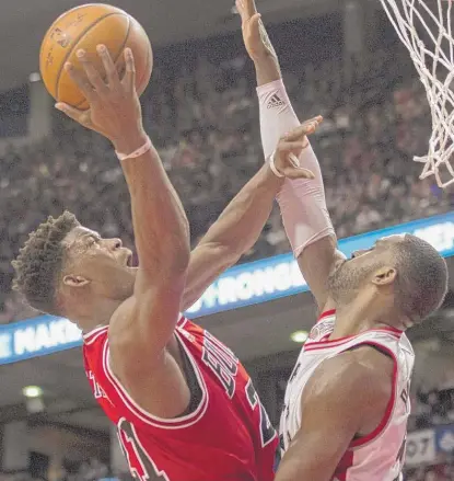  ?? | AP ?? The Bulls’ Jimmy Butler shoots over theRaptors’ Patrick Patterson on Monday. He shot only 5- for- 18 but came up big defensivel­y.