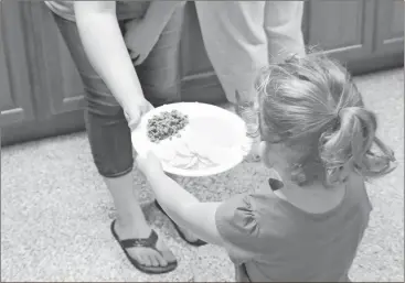  ?? Photos by Kevin Myrick/ Standard Journal ?? This youngster was one of 30 who got fed on Friday, July 21, during a summer lunch program in Aragon. She wanted her nachos plate separated, while other enjoyed it mixed.