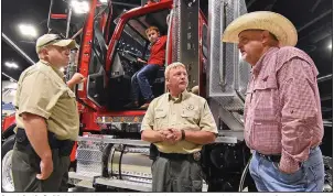  ?? (Arkansas Democrat-Gazette/Staci Vandagriff) ?? Agent Justin Smith (left) and Assistant Chief Russ Lancaster (center), both with the State Department of Agricultur­e’s law enforcemen­t team, talk with Keith Stokes, an agricultur­e project manager for the office of U.S. Sen. Tom Cotton, while he attends the Southwest Forest Expo with his grandson Colt Stokes, 7, on Friday in Hot Springs.