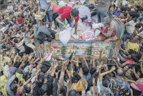  ??  ?? Rohingya Muslims, who crossed over from Myanmar into Bangladesh, stretch their arms out to collect food items distribute­d by aid agencies near Balukhali refugee camp, Bangladesh; inset, a Rohingya Muslim woman is carried to hospital by her son and...