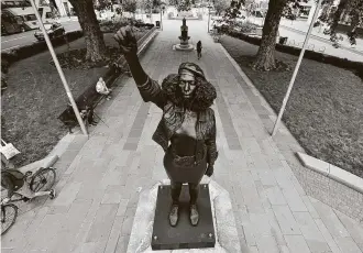  ?? Ben Birchall / Associated Press ?? A new black resin and steel statue of Jen Rein titled “A Surge of Power” stands on a plinth that was left empty after protesters tore down a statue of slave trader Edward Colston in Bristol, England.