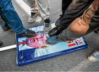  ?? —AFP ?? Protesters in Istanbul step on a poster of US President Donald Trump during a rally.