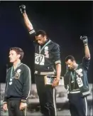  ?? AP file photo ?? U.S. athletes Tommie Smith (center) and John Carlos extend gloved hands skyward in racial protest during the playing of national anthem at the Summer Olympic Games in Mexico City on Oct. 16, 1968.