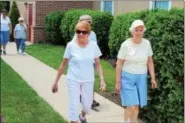  ?? MICHILEA PATTERSON — DIGITAL FIRST MEDIA ?? A group of older adults start a walk from the Sanatoga Ridge retirement community center and follow mapped out arrows on the sidewalk for a mile. The retirement community is using a wellness outreach program to help people age healthy.