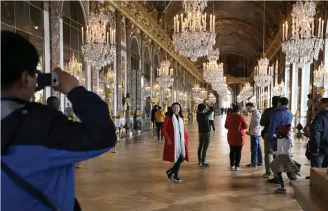  ?? Amr Nabil / Associated Press ?? Visitors pose inside the Hall of Mirrors in the Versailles castle, west of Paris. World traveler Rick Steves’ summer travel tips include getting tickets in advance and following local cultural customs.