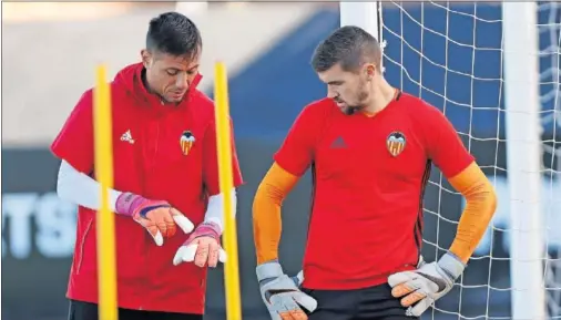  ??  ?? CODO CON CODO. Diego Alves y Mat Ryan, durante un entrenamie­nto en Paterna.