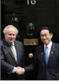  ?? PTI ?? British Prime Minister Boris Johnson, left, greets Japanese Prime Minister Fumio Kishida before their meeting at 10 Downing Street in London, Thursday