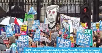  ?? — AFP ?? LONDON : A placard portraying Britain’s Prime Minister Theresa May (center) is held by protesters during a march calling for an end to the ‘crisis’ in the state-run National Health Service (NHS), in central London on February 3, 2018.