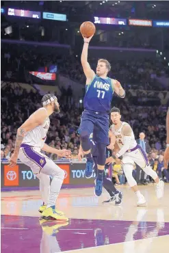  ?? MARCIO JOSE SANCHEZ/ASSOCIATED PRESS ?? Dallas’ Luka Doncic (77) shoots over Los Angeles’ JaVale McGee, left, and Danny Green during the Mavericks’ win over the Lakers Sunday.