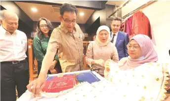  ?? — Photo by Chimon Upon ?? Nancy (second right) looking at how Sarawak keringkam is produced. Also looking on are Abdul Karim (third left), Ting (left) and Sabariah (second left).