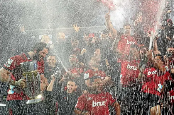  ?? PHOTOSPORT ?? Crusaders captain Sam Whitelock brings the trophy back to his champion team on Saturday night.