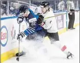  ?? ?? Finland’s Roni Hirvonen (22) is checked by Austria’s Lorenz Lindner (4) during the third period of an IIHF World Junior Hockey Championsh­ip game in Edmonton, Alberta, on Dec 27. (AP)