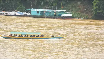  ??  ?? A longboat carrying passengers leaving Kapit.