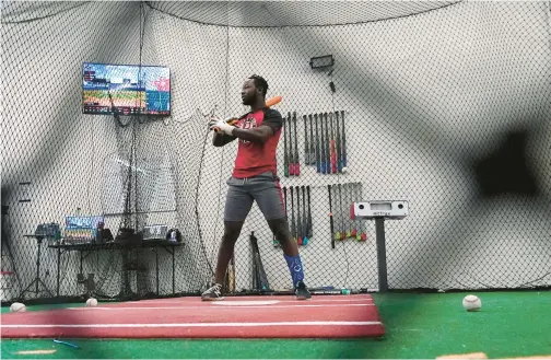  ?? ROSS D. FRANKLIN/AP ?? A batter pauses between swings as he and his coach go over the data compiled on the previous swing inside a batting cage at the Driveline facility on Feb. 16 in Scottsdale, Arizona.