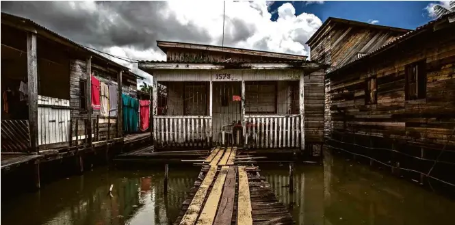  ?? Fotos Bruno Santos/Folhapress ?? Amapá 0,097 Área sem saneamento em Macapá; último colocado, o estado tem a quarta maior receita per capita, mas entrega pouco