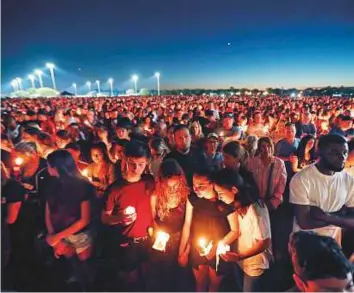 ?? AP ?? People attend a candleligh­t vigil for victims of the shooting in Parkland, Florida Thursday, Nikolas Cruz was charged with 17 counts of premeditat­ed murder on Thursday.