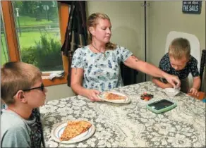  ?? ART GENTILE/BUCKS COUNTY COURIER TIMES VIA AP ?? In an Aug. 13, 2018 photo, Kristin Ognjanovac and two of her sons, Coldyn, 9 and Liam, 3, eat some pizza for dinner. Kristin was diagnosed with Parkinson’s disease 10 years ago.
