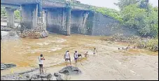  ?? HT PHOTO ?? Villagers from Asangaon Gram Panchayat in Shahapur fix a broken pipeline in six-foot deep water of Bharangi River.