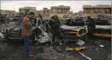  ?? KARIM KADIM, THE ASSOCIATED PRESS ?? Civilians inspect the aftermath of a car-bomb attack in an auto dealership in the southweste­rn al-Bayaa neighbourh­ood, in Baghdad.