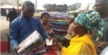  ??  ?? Ashimolowo giving out cash and cloths to one of the widows