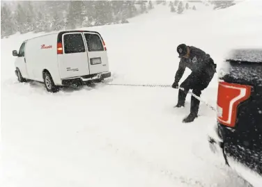  ?? Jason Bean / Reno Gazette-Journal ?? A Nevada Highway Patrol officer helps a stuck motorist on Mount Rose Highway near Reno last week during one of a series of winter storms that have dumped a near-record amount of snow on the Sierra.